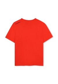 T-shirt en coton rouge, manches courtes, col rond. Présente un logo noir sur l'épaule gauche. Simple, de couleur unie sans motifs.