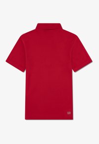 Red polo shirt with a folded collar and short sleeves. Made from smooth fabric, features a small "ULTRA DRY" label on the bottom right.