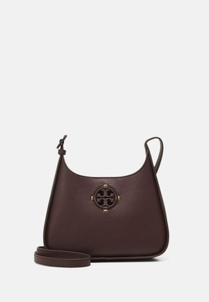 Bolso bandolera de piel marrón oscuro con base redondeada, correa ajustable y logotipo circular en relieve en el centro frontal.