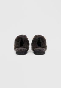 Gray fuzzy slippers with an open-back design, soft texture, and a flat sole. The inside features plush lining for comfort.