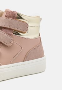Rosa High-Top-Sneaker aus Wildleder und glattem Leder, mit metallisch goldenen Akzenten und Klettverschlüssen. Weiße Gummisohle.