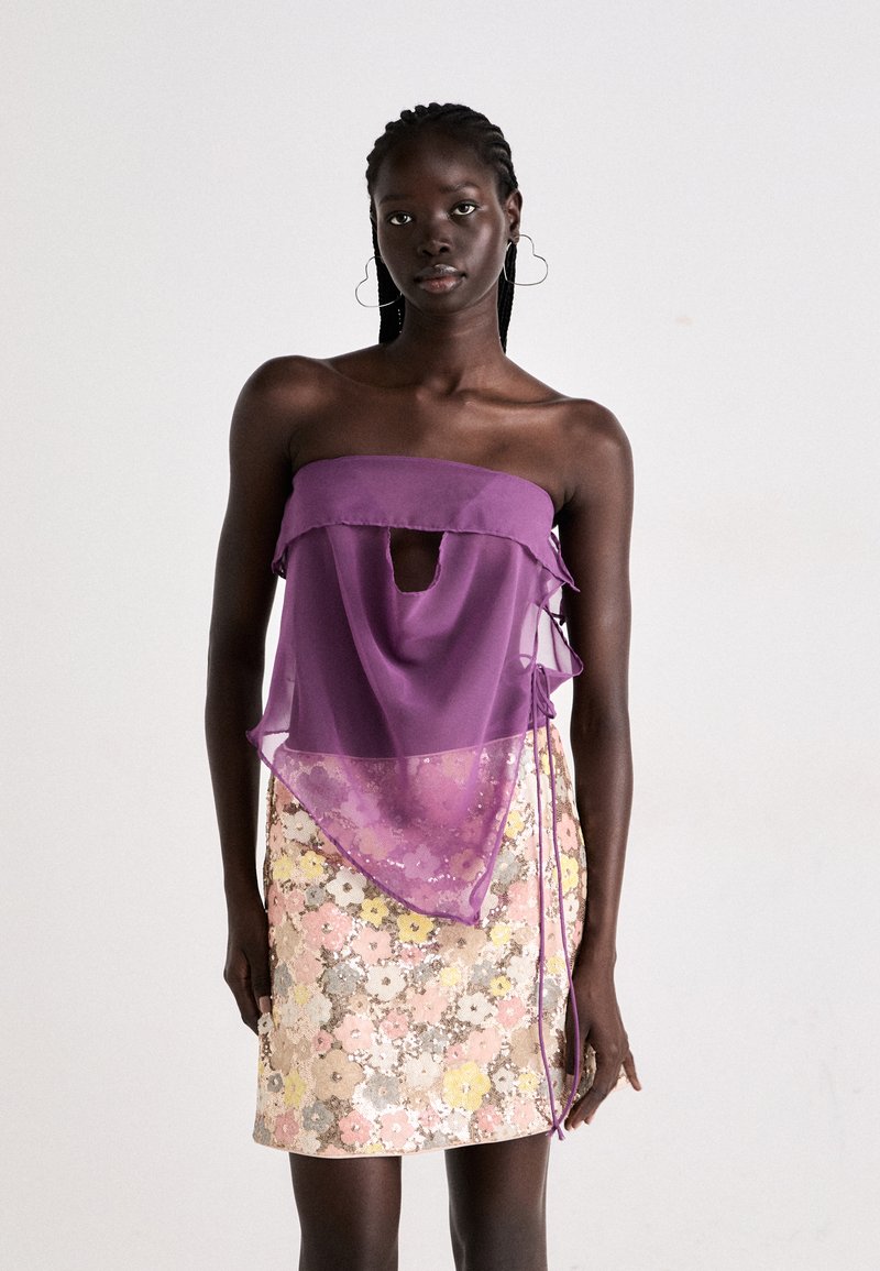 Purple strapless top with a keyhole cutout and ruffled edges; paired with a floral sequined skirt in pastel colors and subtle metallic accents.