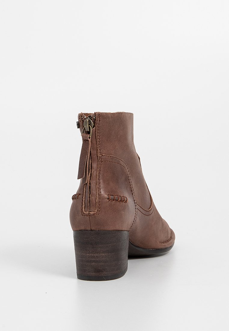 Braune Leder-Stiefelette mit niedrigem Blockabsatz, Reißverschlusschluss und dekorativer Naht entlang der Seite, mit einer glatten Textur.