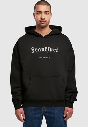 Sort hættetrøje lavet af blødt stof, med et stort grafisk print med teksten "Frankfurt" i stiliseret hvid skrift og en frontlomme.