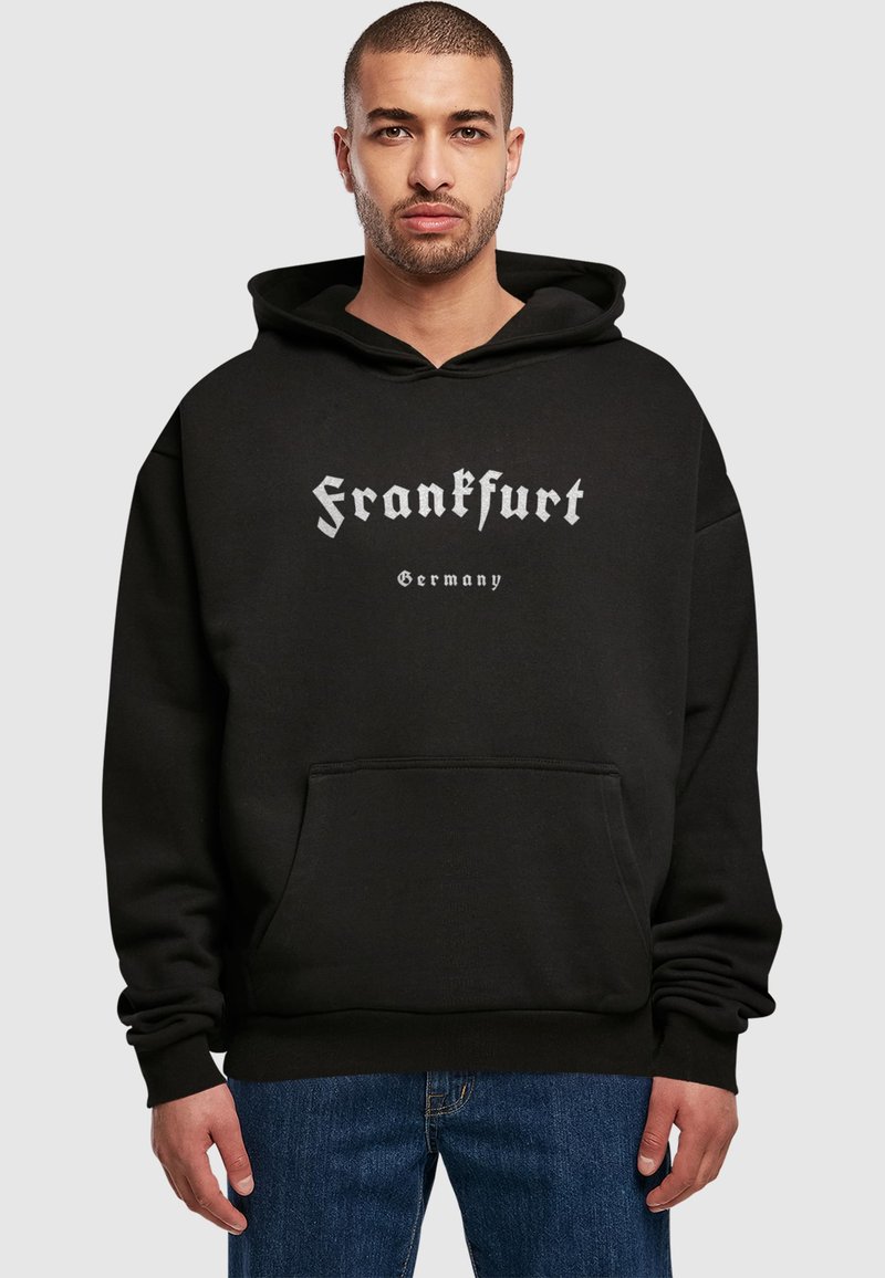 Felpa con cappuccio nera realizzata in tessuto morbido, con una grande stampa grafica che dice "Frankfurt" in caratteri bianchi stilizzati e una tasca frontale.