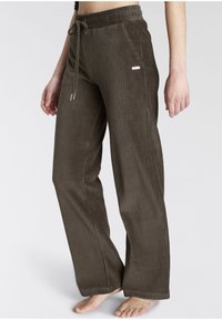 Brown corduroy pants with a ribbed texture, elastic waistband, adjustable drawstring, and a small metallic accent on the side.