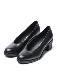 Zapatos de tacón de cuero negro con punta redonda, tacón bajo y bloque, y textura suave. Presentan un ligero diseño de corte en la parte delantera.