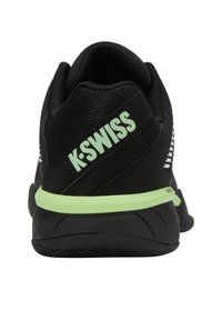 Pantofii sport negri cu partea superioară din plasă și material sintetic, având un accent verde lime pe călcâi și logo. Vederea din spate evidențiază talpa texturată.