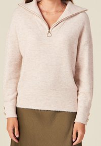 Maglione lavorato a maglia di un rosa chiaro con colletto a mezza zip, polsini e bordo a coste, con dettagli in bottone sulle maniche. Tessuto morbido, vestibilità rilassata.