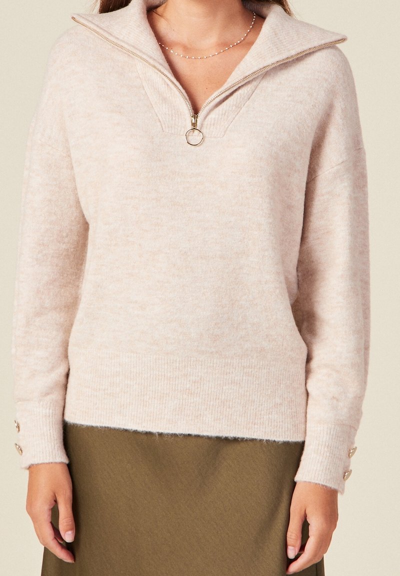 Maglione lavorato a maglia di un rosa chiaro con colletto a mezza zip, polsini e bordo a coste, con dettagli in bottone sulle maniche. Tessuto morbido, vestibilità rilassata.