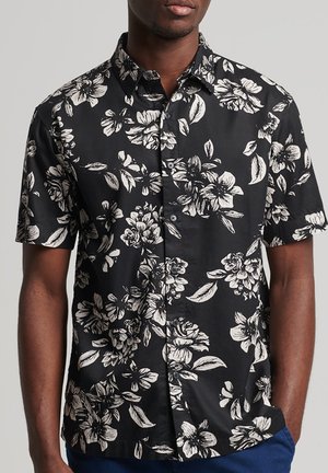 Zwart shirt met korte mouwen en witte bloemenprint, knoopsluiting, lichte stof en een ontspannen pasvorm. Minimalistisch ontwerp met klassieke knopen.