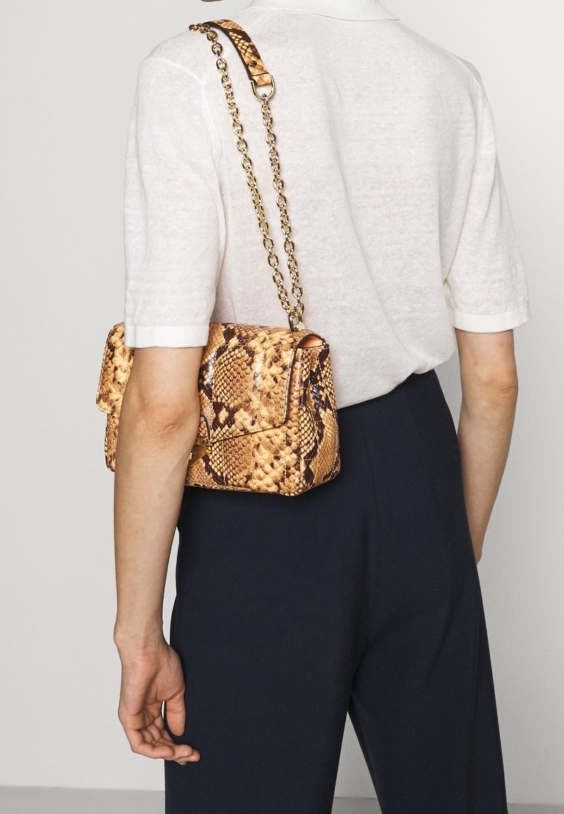 Torebka w wzór węża w odcieniach złota i brązu z łańcuszkowym paskiem. Kompaktowy design z klapą i teksturowaną powierzchnią.