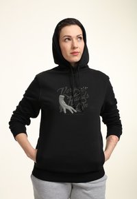 Felpa nera con grafica frontale che riporta la scritta "Very Hands On" in grigio. Il tessuto sembra morbido; presenta un cappuccio con coulisse e polsini a coste.