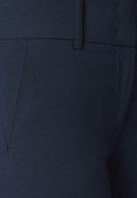 Granatowe, dopasowane spodnie wykonane z gładkiego materiału, z płaskim przodem, bocznymi kieszeniami oraz sylwetką slim-fit o delikatnej fakturze.