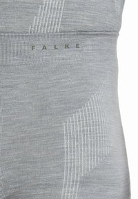 Szare legginsy z teksturowanym wzorem z subtelnym prążkowaniem, dopasowanym krojem i nadrukiem nazwy marki "FALKE" w jasnym kolorze.