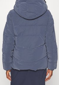 Puffer jacket in a dark blue color with a hood, featuring a quilted design and elastic cuffs for warmth and comfort.