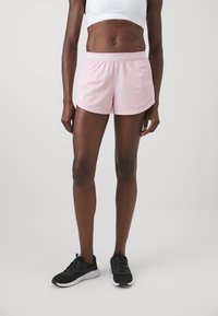 Roze atletske kratke hlače napravljene od lagane tkanine, s glatkom teksturom i elastičnom waistband-om na kojem je u bijelom ispisano "UNDER ARMOUR".