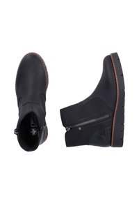 Bottines en cuir noir avec un bout arrondi, une fermeture éclair sur le côté, des accents texturés et une semelle en caoutchouc brun avec des détails de crampons.