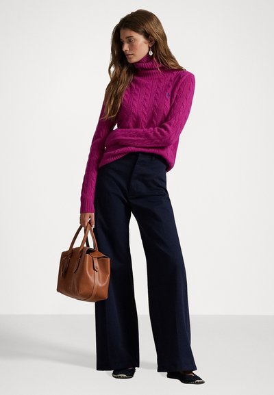 Pulover cu guler înalt, tricotat în torsadă, de culoare magenta, pantaloni largi, cu talie înaltă, de culoare bleumarin, și o geantă de mână marron, împreună cu pantofi negri cu vârful ascuțit, cu accente.