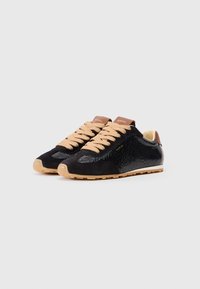 Czarne sneakersy z teksturowanej skóry i zamszu, beżowe sznurowadła, brązowe skórzane akcenty oraz gumowa podeszwa z wzorzystym bieżnikiem.