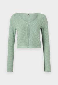 Ανοιχτό πράσινο, μακρυμάνικο, καπρι κροσέ ζακέτα με ένα κουμπί στο στήθος και φαρδύ ντεκολτέ.