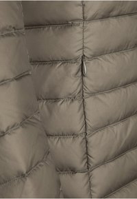 Bruine gewatteerde pufferjas met een doorgestikt patroon, met een gladde textuur en een klein ritssluitingzakje aan één kant.