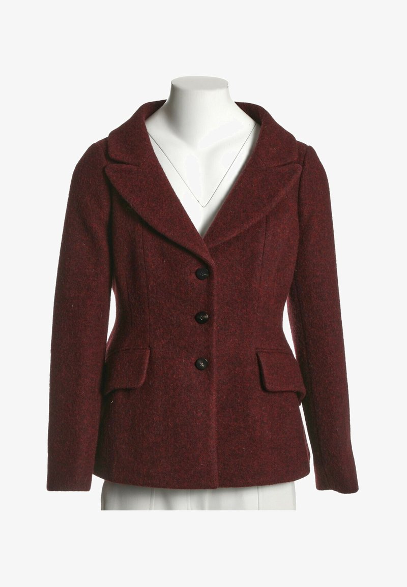 Blazer en laine bordeaux pour femme avec revers crantés, trois boutons noirs, manches longues et deux poches avant à rabat sur un mannequin blanc.