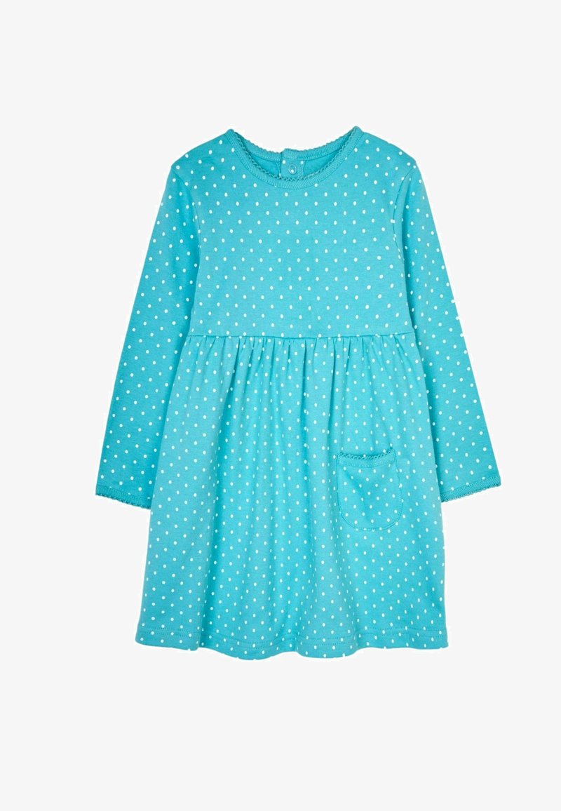 Turkoosi pitkähihaine mekko pehmeästä kankaasta, jossa on valkoisia pallosia, liehuva hame ja pieni tasku edessä. Napitus kauluksessa.