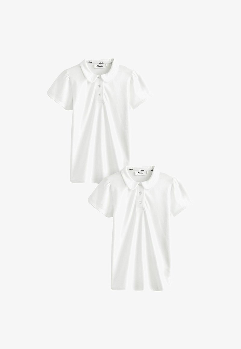 Dvě bílé polo trička vyrobené z bavlny, s krátkými nafouknutými rukávy, zapínáním na knoflíky a kulatým límcem. Hladká textura, jednoduchý design.