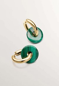 Pendientes de metal en tono dorado que presentan piedras circulares de malaquita con rayas verdes, conectadas por elegantes aros entrelazados y suaves.