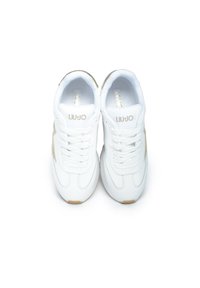 Sneakers bianchi con dettagli dorati, caratterizzati da una texture liscia, design con lacci e collare imbottito. Logo visibile sulla linguetta.