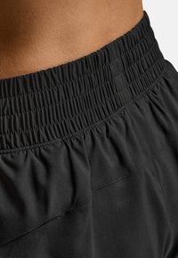 Svarta sportshorts med resår i midjan och slät tygstruktur, med fokus på komfort och flexibilitet.