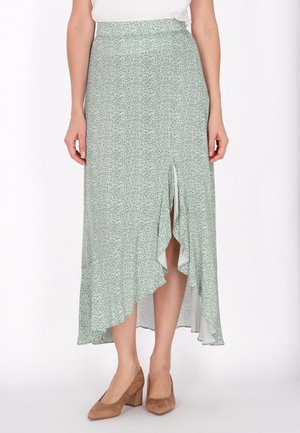 Groene maxi rok met bloemenpatroon en een hoge-lage zoom, met een split aan één kant en van een zachte, lichte stof. Gepaard met tan hakken.