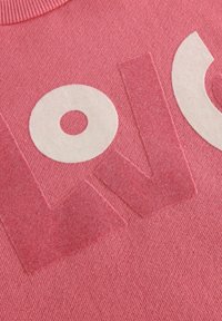 Felpa rosa con una stampa testurizzata "LOVE" in crema, dotata di un colletto a coste e una morbida texture del tessuto.