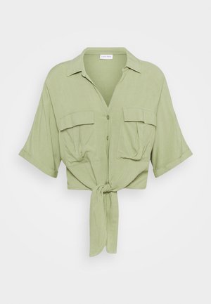 Lichtgroen cropped shirt van zachte stof, met een gestrikt voorpand, korte mouwen, twee borstzakken en een kraag.