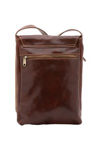 Zaino in pelle marrone con una finitura liscia, dotato di una tasca con zip frontale, manici superiori e spallacci. Cuciture robuste visibili.
