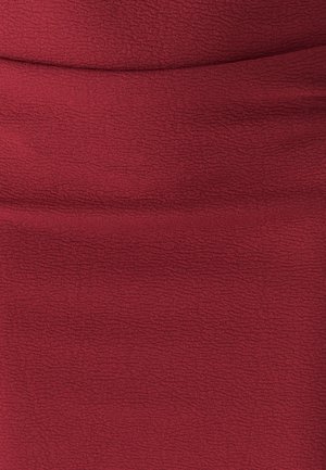 Burgundy textured stretch fabric featuring a subtle, slightly wavy pattern, suitable for a fitted garment.