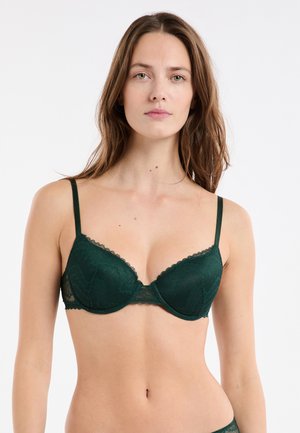 Soutien-gorge en dentelle vert foncé avec armature, bords festonnés et bretelles réglables, présentant un motif texturé et une bordure transparente.