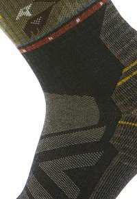 Stickade strumpor med en mörkgrön och svart färgskala, med geometriska mönster, gula accenter och ett naturlandskapsmotiv nära skaftet.