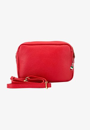 Red textured leather crossbody bag with adjustable strap and gold hardware, featuring a small Italian flag zipper charm.