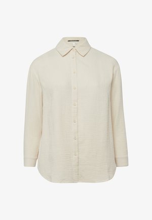 Cremefarbenes, langärmeliges Hemd mit Knöpfen und spitzem Kragen aus strukturiertem Stoff, dargestellt auf einem schlichten weißen Hintergrund.