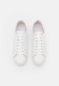 Sneakers in pelle bianca con una texture liscia, punta rotonda, dettagli dorati sui bordi e lacci bianchi. Design perforato sui lati.