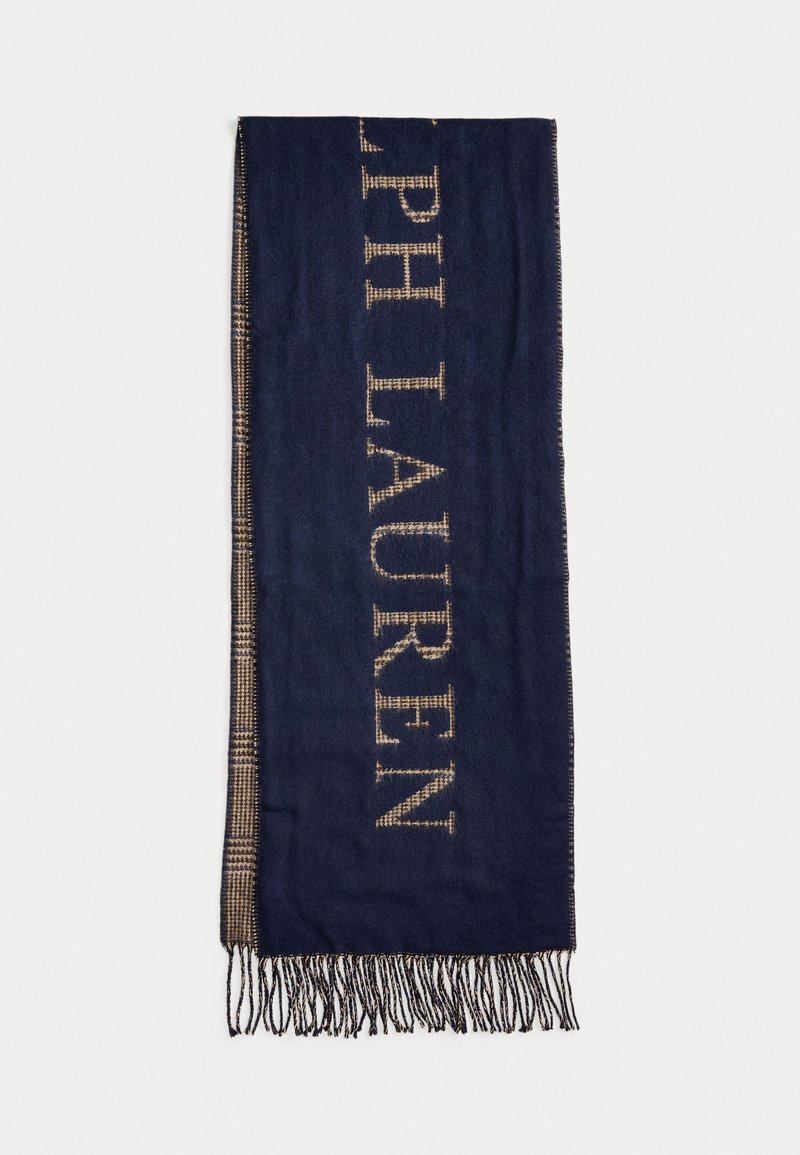 Tumši zilas krāsas šalle, kas izgatavota no mīksta auduma, ar lieliem bežiem burtiem "RALPH LAUREN" gar vienu malu un frandētiem galiem, kas piešķir papildu tekstūru.