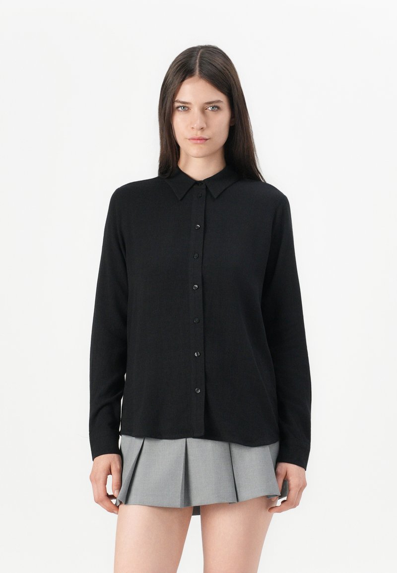 Schwarz, langärmliges Hemd mit Button-Down-Kragen, aus glattem Stoff, mit geradem Schnitt und subtiler Karomusterung.