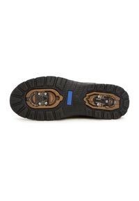 Suela de zapato de goma negra con patrones de textura, un punto de anclaje metálico y un acento azul. Presenta elementos de diseño duraderos y resistentes.