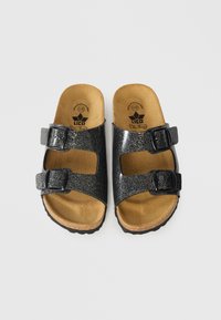 Μαύρα σανδάλια με γκλίτερ και δύο ρυθμιζόμενες αγκράφες, με πάτο από φελλό. Η υφασμένη σόλα από καουτσούκ προσφέρει καλά κράτημα.