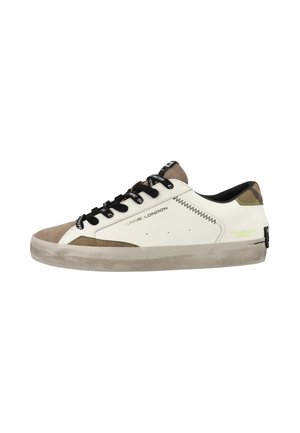 Sneaker basse bianche con accenti beige e oliva, lacci neri, marchio "Crime London" sul lato e suola grigia leggermente consumata.