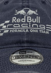 Sötétkék állítható sapka ívelt napellenzővel, fehér hímzett logókkal: "Red Bull Racing" és "Formula One Team." Új Era felirat található rajta.