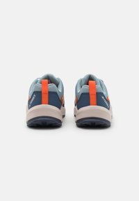 Scarpe da ginnastica blu e grigie con dettagli arancioni, tomaia in rete testurizzata, suole imbottite e suole nere robuste per una buona trazione.