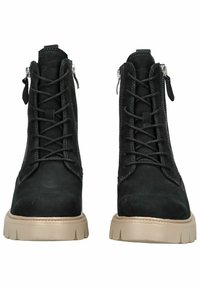 Stivaletti neri in suede con lacci, alla caviglia, dotati di cerniere laterali e suole in gomma beige spesse, visti frontalmente.